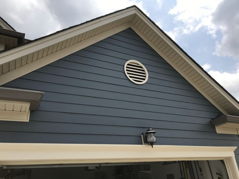 Blue-gray lap siding on a gable with cream trim