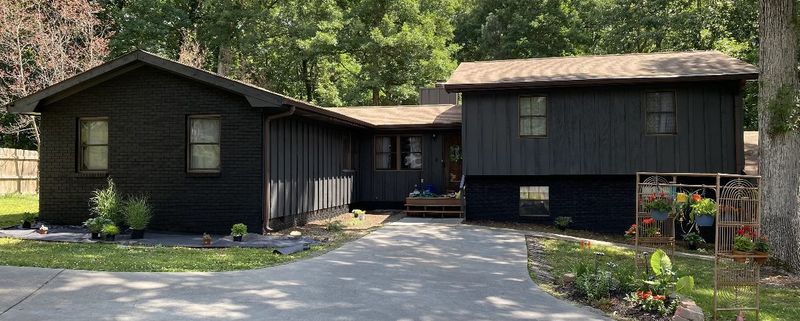 Wide view of a two-part house after a full dark exterior repaint