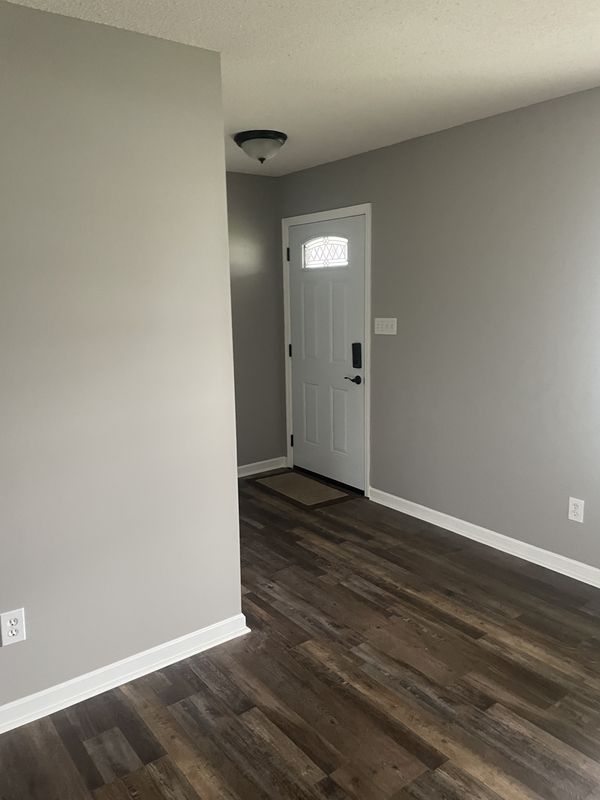 Entry hallway with freshly painted light gray walls and white trim