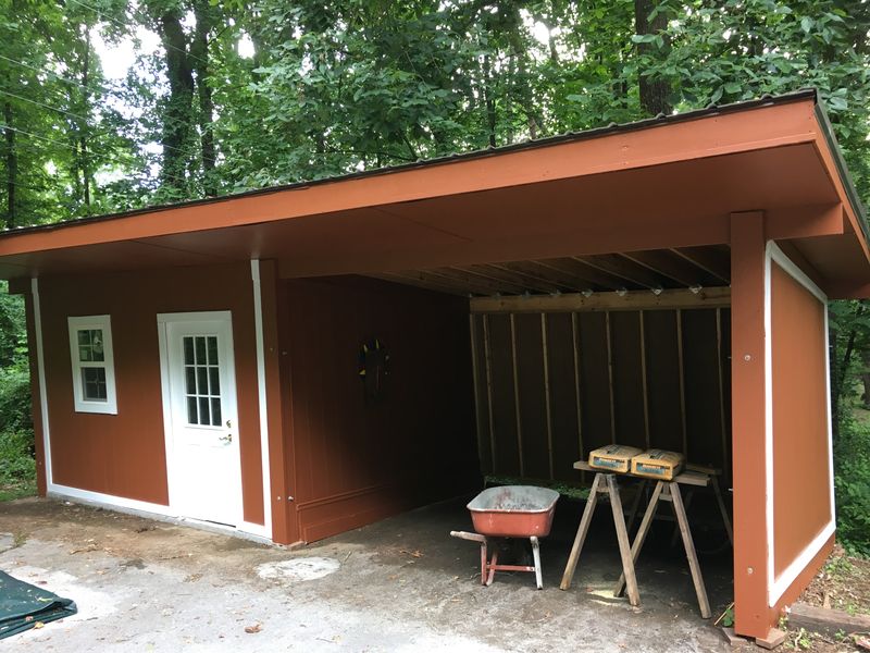 Open-front shed painted red-brown with white trim